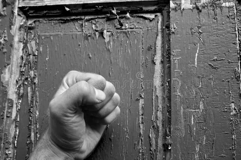 can-you-hear-me-knocking-black-white-fist-pounding-weathered-old-door-39995891